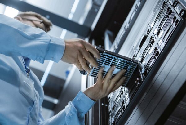 a man inserting a harddrive into a serverrack